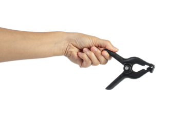A studio shot of a black plastic spring clamp in hand isolated on a transparent background