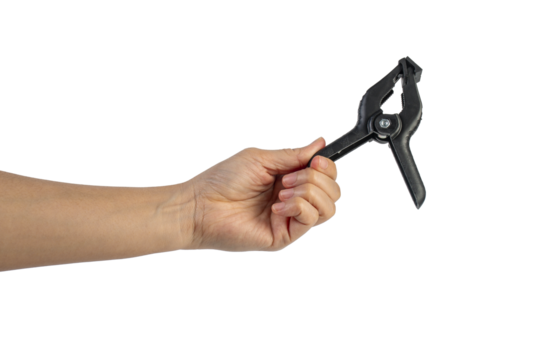 A studio shot of a black plastic spring clamp in hand isolated on a transparent background