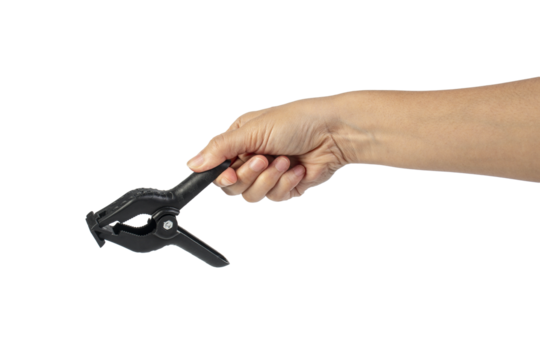 A studio shot of a black plastic spring clamp in hand isolated on a transparent background