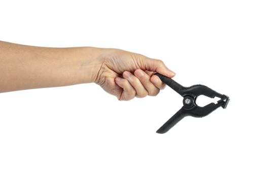 A studio shot of a black plastic spring clamp in hand isolated on a transparent background