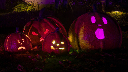 Handmade carved jack-o-lanterns glow in the dark during Halloween season.