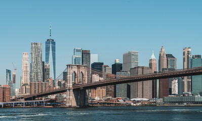 Naklejka premium Brooklyn Bridge with Manhattan skyscrapers in daylight, realistic photo style, blue sky background. Concept of NYC architecture and urban skyline