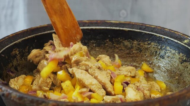 In a deep cast-iron skillet, chicken is fried in vegetable oil with teriyaki sauce