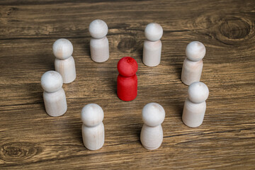 red wooden figure stand to the wooden group crowd. leadership and teamwork concept