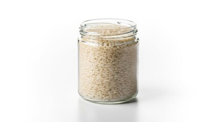 Uncooked brown rice in a glass jar isolated on white for healthy eating and pantry storage concepts