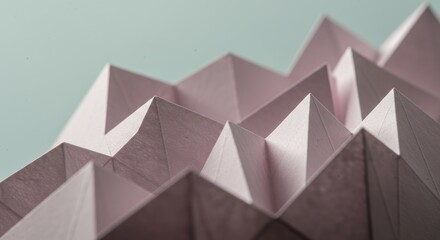 Delicate pink paper folded into sharp, geometric peaks, creating a textured abstract pattern
