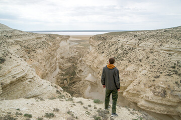 A man stands on the edge of a canyon