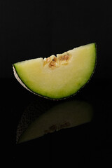 Vibrant Melon Slice on Reflective Black Background