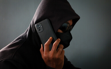 Phone Scammers, mysterious man with phone, cyber theft and fraud, mobile phone used for hacking, secret attacks on privacy.