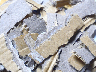 Brown cardboard, torn into numerous pieces.