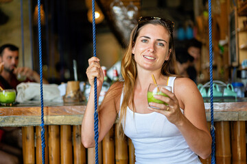 Solo female traveler enjoying a drink in a bar in El Nido, Philippines