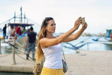 Woman taking a selfie in El Nido, Philippines, on a sunny day