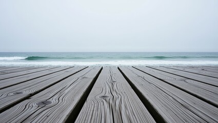 Wooden pier leading to ocean waves on overcast day