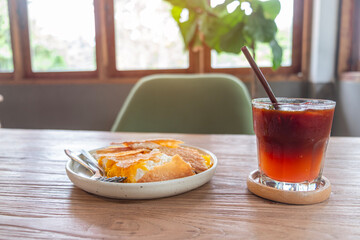 Crispy roti filled with shredded egg yolk and cream, served with strawberry juice for breakfast.
