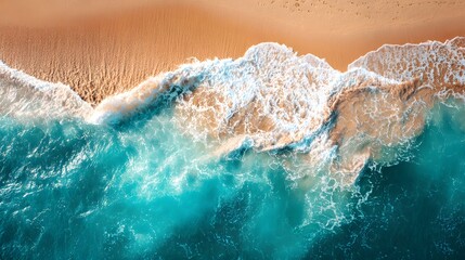 Aerial view of ocean waves crashing on a golden sandy beach.
