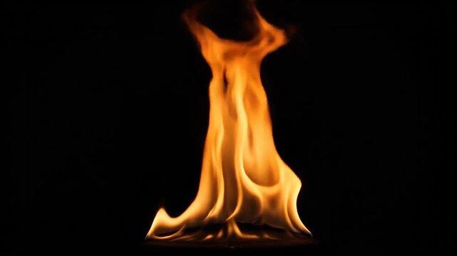 Vibrant orange flames dance and flicker against a stark black background with realistic texture and movement, capturing the raw energy of fire in a dark setting with dramatic illumination.