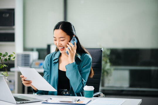 Happy asian business woman have the joy of talking on the smartphone, tablet and laptop video call on the modern office