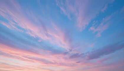 Pastel pink and blue sunset sky with soft wispy clouds