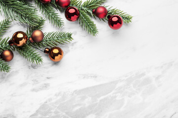 Christmas background, pine branches with christmas balls on marble table, top view