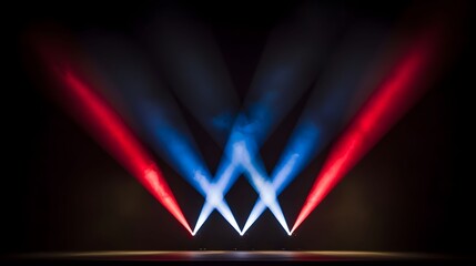 The image features stage lighting with beams of red and blue light converging from the floor against a dark background, creating a dynamic and dramatic visual effect.