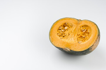 白背景に映えるカットされたかぼちゃの鮮やかな断面食材イメージとコピースペース