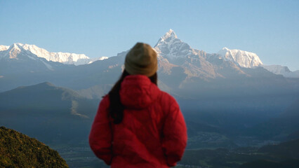 Blurred rear view of a woman traveler looking at Machapuchare peak, Annapurna mountain range in...