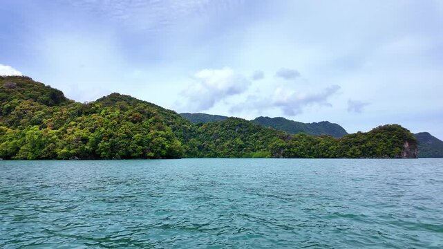 Scenic view of Pulau Dayang island from a moving speedboat on clear tropical waters