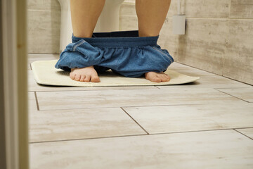 Person sitting on toilet with pants down