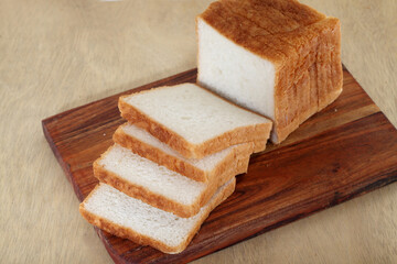 Fresh bread slices on cutting board 