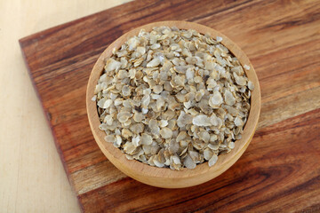 Pearl millet flakes in wooden bowl,close up