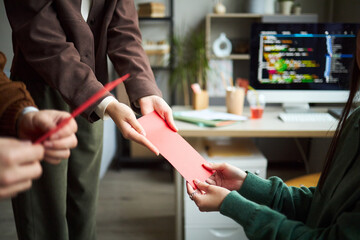 Young Asian businessmen and businesswomen exchanging red envelopes in modern office, hands of young...