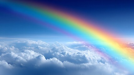 A stunning rainbow stretches from one side of the horizon to the other, illuminating the sky with vivid colors above a sea of soft, white clouds