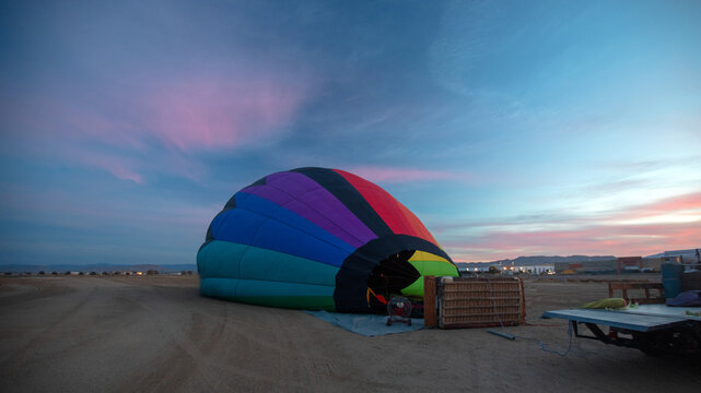Early morning sunrise view of inflating hot air balloon in the Inland Empire of Southern California United States