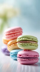 Obraz premium Assorted Colorful Macaron Cookies Stacked in Soft Natural Light on a White Wooden Table
