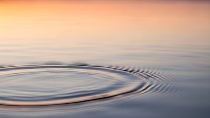 Calm water surface reflects a peaceful sunset sky with gentle ripples creating a serene atmosphere. isolated on white background