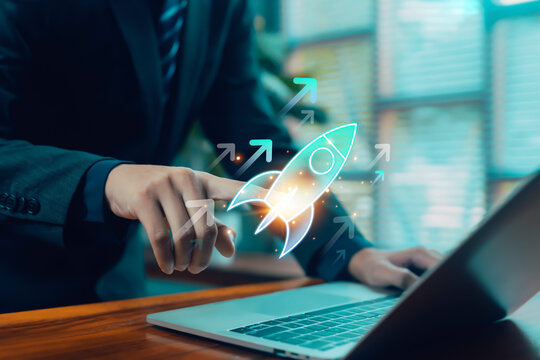 A glowing rocket icon launching from a business hand above a laptop, symbolizing startup growth, innovation, digital strategy, rapid progress, and future success in modern business development.