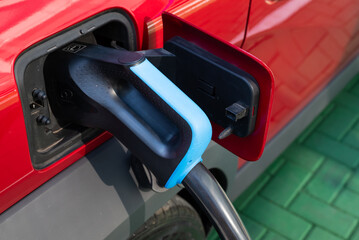 Electric car plugged into public charger, showing clean technology and the rise of sustainable mobility solutions.