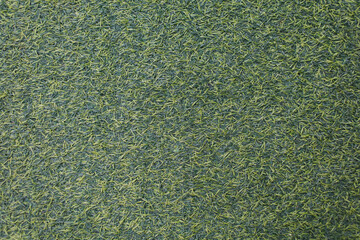 Close-up photo of green artificial grass suitable for use as a background.