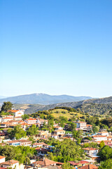 Fototapeta premium Sirince village on the background of blue sky and green hills. Popular tourist destination, old Greek village. Sirince, Izmir. 