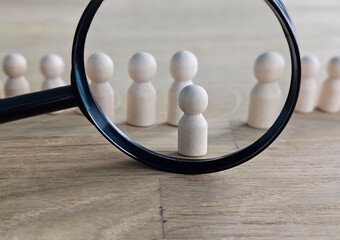 Recruitment and job search magnifying glass with wooden people concept for human resources and...