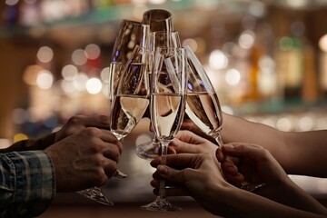 Cheers with champagne flutes in a celebratory bar setting