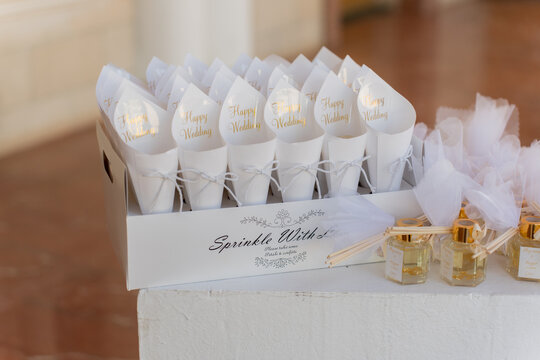 Decorative wedding favors and confetti cones arranged elegantly for guests at a joyful outdoor celebration