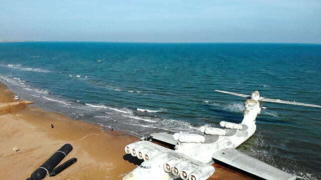 Abandoned lun class ekranoplan resting on sandy beach. Media