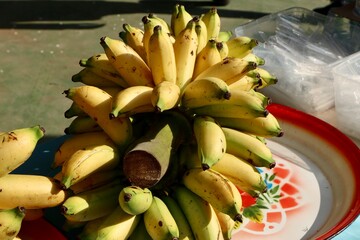 yellow and green asian bananas on banana leaves and blurry background