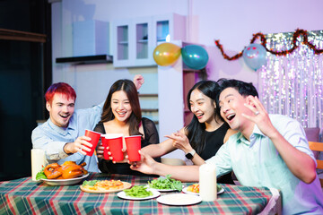 young friends raise red party cups in celebration at a fun indoor dinner party with food, laughter, and festive decorations in a colorful neon lit home
