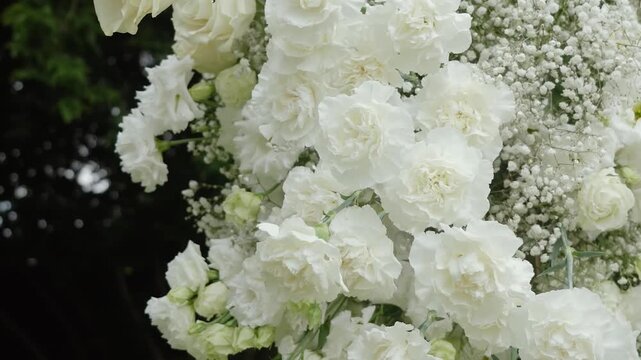 Beautiful white roses and eustoma flowers with petals and a romantic atmosphere. Outdoor wedding ceremony for the bride and groom. Decor and floristry.