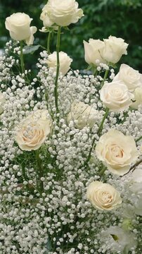 Beautiful white roses and eustoma flowers with petals and a romantic atmosphere. Outdoor wedding ceremony for the bride and groom. Decor and floristry.