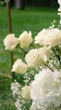 Beautiful white roses and eustoma flowers with petals and a romantic atmosphere. Outdoor wedding ceremony for the bride and groom. Decor and floristry.