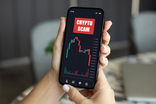 woman hand hold phone with chart of scam crypto coins