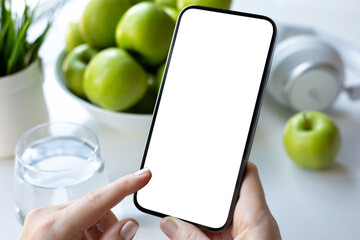 Female hands holding phone with isolated screen background green apples